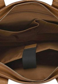 Interieur van een bruine leren handtas met een gladde textuur, waaronder een ritsvak en twee open vakken voor organisatie.