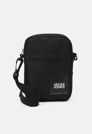 Sort crossbody-taske med justerbar strop, firkantet form og hvid "JACK & JONES"-logo på forvognen.