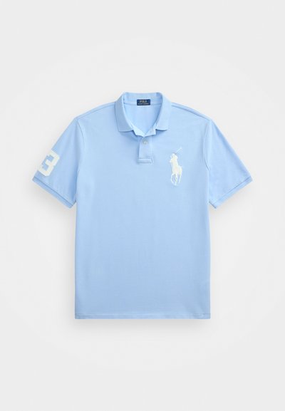 Light blue polo shirt made of cotton. Features a two-button placket, short sleeves, embroidered white logo on the chest, and number 3 on the sleeve.