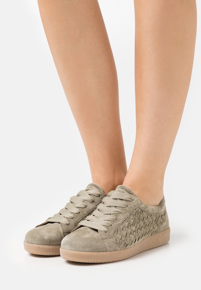 Sneaker in suede grigio chiaro con trama intrecciata sul lato, design con lacci e suola in gomma beige. Finitura liscia e stile low-top.