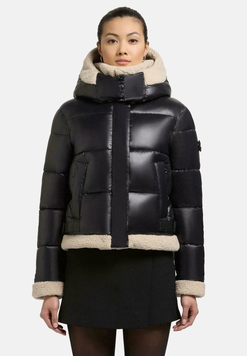 Schwarze Pufferjacke mit cropped Design, ausgestattet mit einem beigen Kunstfellkragen und -manschetten sowie schrägen Seitentaschen. Glatte, glänzende Oberfläche.