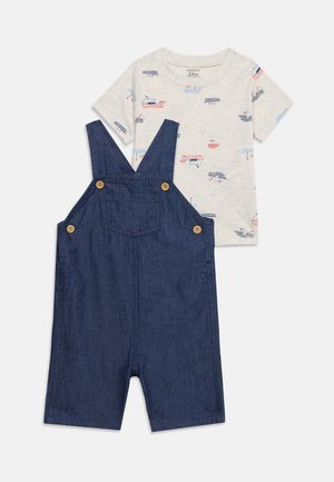 Detský dvojdielny outfit so námornícky modrým riflovým overalom na kraťasy s drevenými gombíkmi a bielym tričkom s krátkym rukávom s motívom lodí.