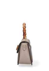 Borsa strutturata in pelle beige con forma curva, dotata di manico in bambù e hardware dorato. Cuciture a contrasto che accentuano i lati.