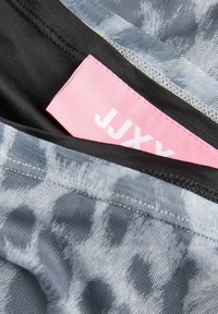 Sportstøj med et gråt leopardprint design, sort inderside og et rosa mærke med "JJXY" i hvid tekst.