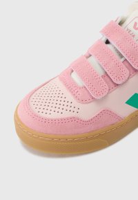 Roosad vabaajajalatsid, mille pealiskihiks on seemisnahk ja nahk, kolm takjakinnitusega rihma, auguline varvas ning kummikummist tallapõhi. Roheline logodetail.