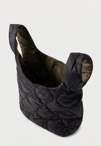 Τσάντα tote μαύρη, με επένδυση, με στρογγυλεμένες γωνίες και φαρδιές λαβές. Το εσωτερικό είναι ελαιοπράσινο. Διαθέτει κλείσιμο με κουμπί snap. Μαλακή, επενδεδυμένη υφή.