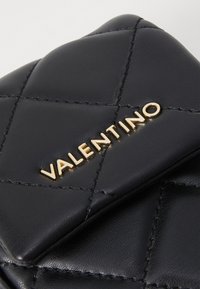 Schwarze, gesteppte Lederbrieftasche mit goldfarbenem "VALENTINO"-Logo, strukturiertem Oberflächen und Rautenmuster-Steppung.
