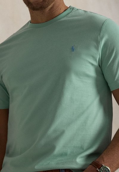 Μπλούζα κοντομάνικη σε μέντα κατασκευασμένη από απαλό βαμβάκι, με μικρό μπλε λογότυπο στο αριστερό μέρος του στήθους και κλασικό στρογγυλό γιακά.