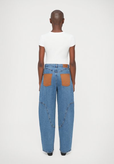 Blå denim vida byxor med kontrasterande bruna bakfickor, med synlig sömnad och midja i hög design.