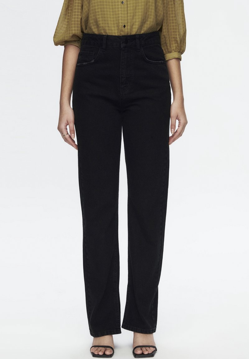 Jean noir taille haute avec une coupe droite. Style classique à cinq poches, tissu denim robuste et détails de couture minimalistes.