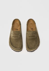 Grüne Wildleder-Mokassin-Style Slipper mit runder Zehenpartie, gestickten Details und strukturierten Sohlen für besseren Grip. Das Innere verfügt über eine natürliche Stoffauskleidung.