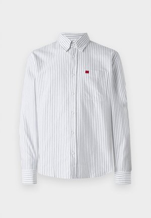 Πουκάμισο με κουμπιά σε ανοιχτό γκρι και λευκές κάθετες ρίγες, με τσέπη στο στήθος και μικρή κόκκινη ετικέτα λογότυπου στην αριστερή πλευρά.