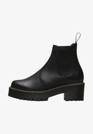 Black leather ankle boot with elastic inserts, stitched detailing, chunky platform sole, and a pull tab at the back for easy wearing.