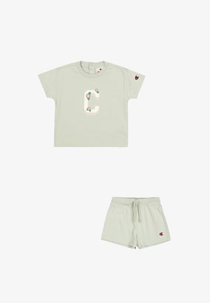 T-shirt en coton vert clair à manches courtes, avec un grand design de la lettre "C" accentué de fleurs. Associé à un short à cordon coordonné.
