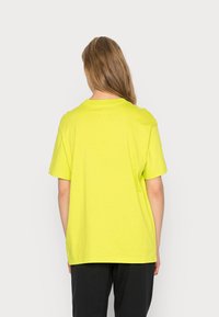 Neon gul kortärmad t-shirt med rund halsringning. Mjukt bomullsmaterial, avslappnad passform och ren design utan mönster eller accentuerande detaljer.