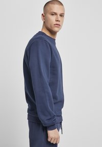 Marineblå sweatshirt i blød bomuldsblanding, med ribbede manchetter og kant, rund halsudskæring og en afslappet pasform. Glat tekstur, minimalistisk design.