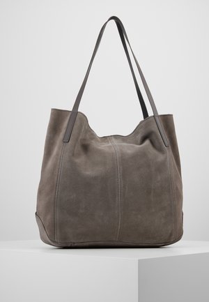 Grote zachte grijze suède totebag met dubbele dunne schouderbanden, gestructureerde bodem en subtiele verticale stiksels op een wit displayvlak.