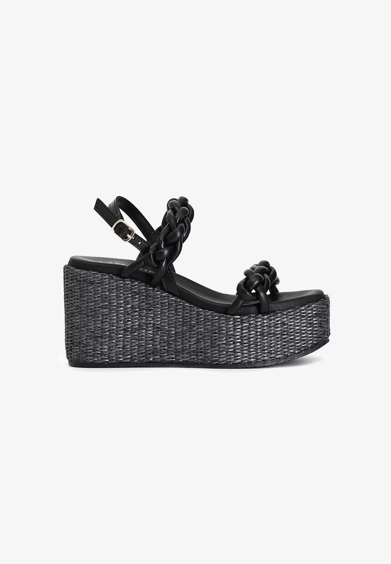 Sandalias de plataforma negras con parte superior de tejido trenzado, correas trenzadas, hebilla ajustable en el tobillo y un cuña entrelazada texturizada en negro y gris.