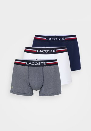 Drei Paare Herren-Boxershorts: eine in Marineblau, eine in Weiß und eine graue mit dünnen Streifen. Alle verfügen über einen elastischen Taillenbund mit Markenlogo.