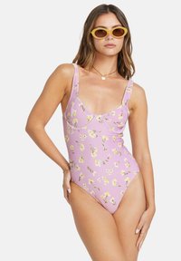 Maillot de bain une pièce rose avec imprimé floral, présentant une encolure dégagée, des bretelles larges et un design de jambe échancrée modéré.