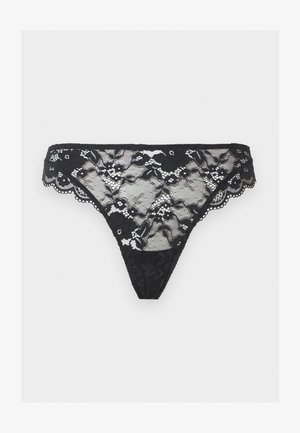 Μαύρο δαντελένιο στρινγκ με λουλουδένια σχέδια και κυματιστά άκρα, εμφανίζεται σε απλό ανοιχτό φόντο.