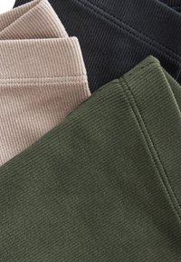 Drei Rippenstoffproben in verschiedenen Farben: Beige, Schwarz und Dunkelgrün. Jede hat eine strukturierte Oberfläche und sichtbare Nähte.