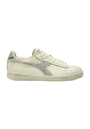 Sneakers in pelle beige con dettagli in suede grigio chiaro, decorazioni perforate e una suola in gomma testurizzata con un motivo.