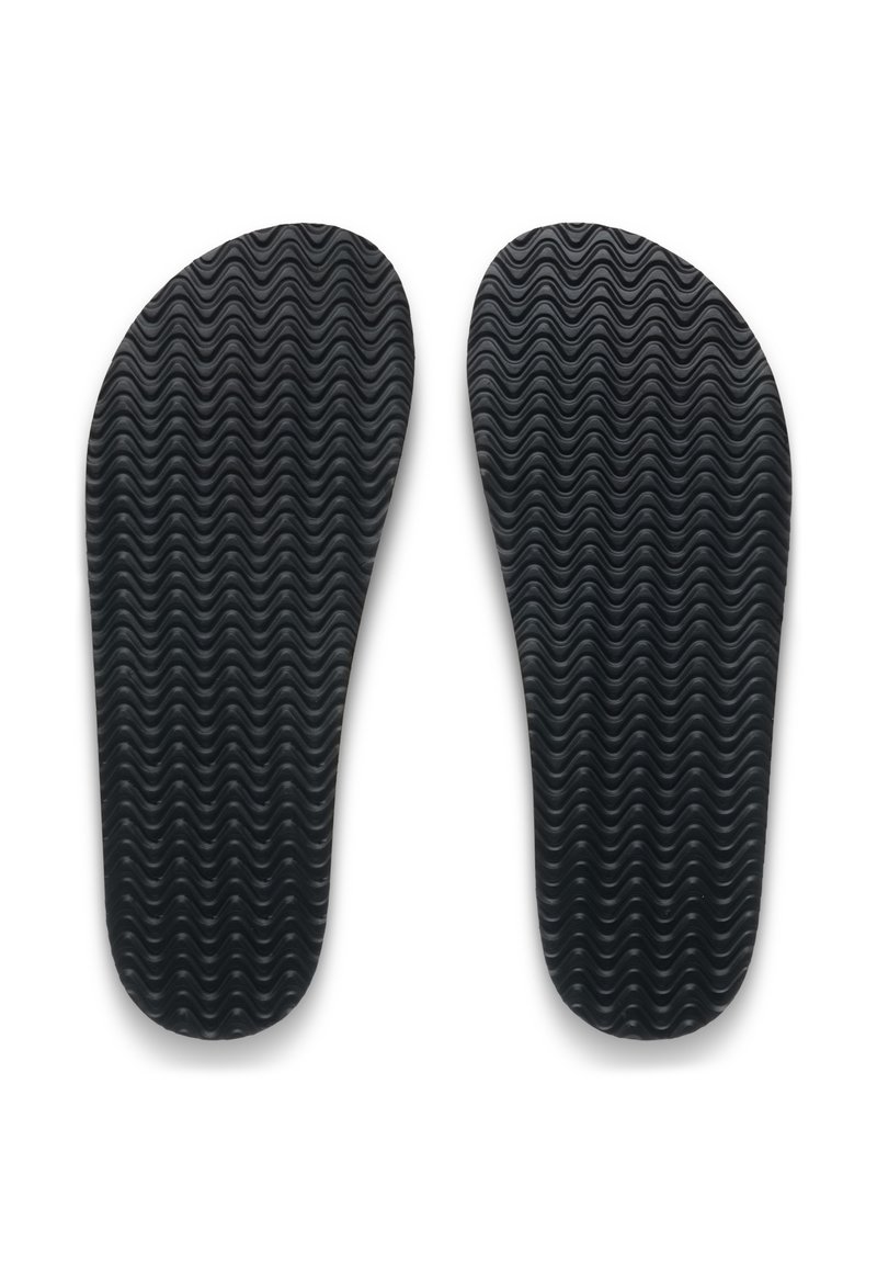 Soletta in gomma nera con motivo a onde, leggermente allungata, texture liscia, progettata per comfort e adattamento all'interno delle scarpe.