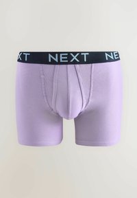 Lila boxer alsónadrág fekete derékrésszel, amelyen a "NEXT" márkaneve fehérrel van feltüntetve. Az anyag sima, testhez álló fazonú, minták nélkül.
