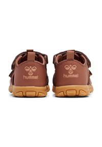 Bruna sneakers med en texturerad överdel, som har två kardborreband, en logotyp på hälen och en sula av gummigummi.