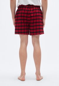 Καρό μποξεράκια σε κόκκινο και μαύρο με ελαστι κή μέση, κατασκευασμένα από απαλό ύφασμα. Διαθέτουν άνετη εφαρμογή και ίσιο τελείωμα.