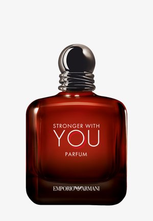 Glasperfume flaske med en rundet base, ravfarvet, sølv låg med riller og hvid tekst med ordene "Stronger With You Parfum."