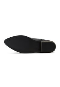 Suela de zapato de cuero negro con una forma elegante y puntiaguda. Bordes texturizados y superficie lisa. Tacón plano con un ligero brillo cerca del talón.