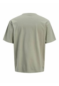 Koszulka krótki rękaw, okrągły dekolt w stonowanym zielonym kolorze, wykonana z miękkiej bawełny, charakteryzująca się luźnym krojem i brakiem widocznych grafik lub wzorów.