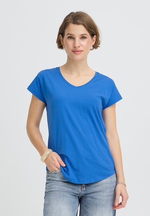 Kék V-nyakú póló rövid ujjakkal és laza szabással. Az anyag puhanak tűnik, sima textúrájú, egyenes szegéllyel szabva.