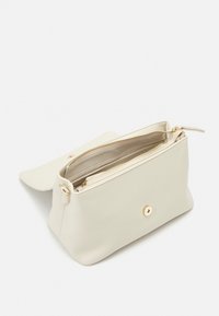 Vit läderväska med en slät yta, rektangulär form, guldfärgad dragkedja och metalldetaljer, samt ett knäppe. Dragkedjeavdelning synlig inuti.