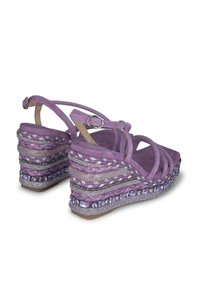 Sandali wedge in suede viola con design intrecciato, impreziositi da dettagli di perline e una chiusura a fibbia sulla cinghia alla caviglia.