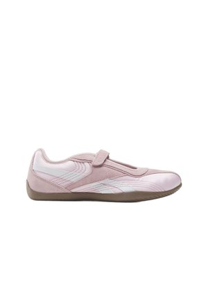 Zapatilla deportiva de perfil bajo en rosa claro con rayas blancas, una tira de velcro y suela de goma marrón, mostrada de lado sobre un fondo blanco.
