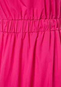 Růžové šaty s nařasením v pase. Hladká, lehká tkanina s mírně lesklou texturou. Zvrásněný vzhled po celé tkanině.