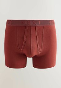 Boxers rouges rouillés pour hommes avec une large ceinture élastique embossée "NEXT" et des détails de couture visibles à l'avant.