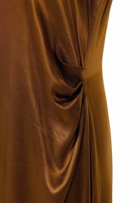 Tissu satin marron avec détail drapé froncé créant des plis doux et un léger éclat sur une texture lisse.