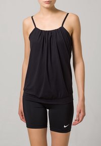 Sort ærmeløs tanktop med samlet hals, blødt stof, løs pasform, parret med sorte stramme shorts med et hvidt Nike-logo.
