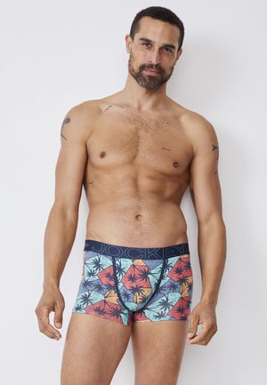 Boxer briefs con un diseño ajustado, que presentan un patrón multicolor de palmeras. El material es suave, con una cinturilla azul marino que muestra el logo "JOCKEY".