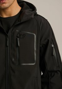 Czarna kurtka na zamek z ocieplaną kapturą, wieloma zamykanymi kieszeniami i eleganckim logo na klatce piersiowej. Materiał jest gładki i trwały.