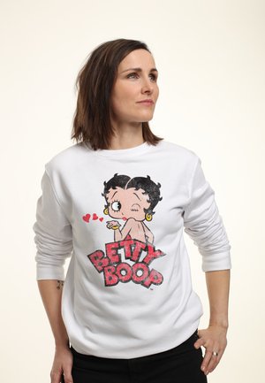 Witte sweatshirt met een kleurrijk Betty Boop ontwerp, versierd met rode harten en vetgedrukte tekst. De stof lijkt zacht en heeft een losse pasvorm.