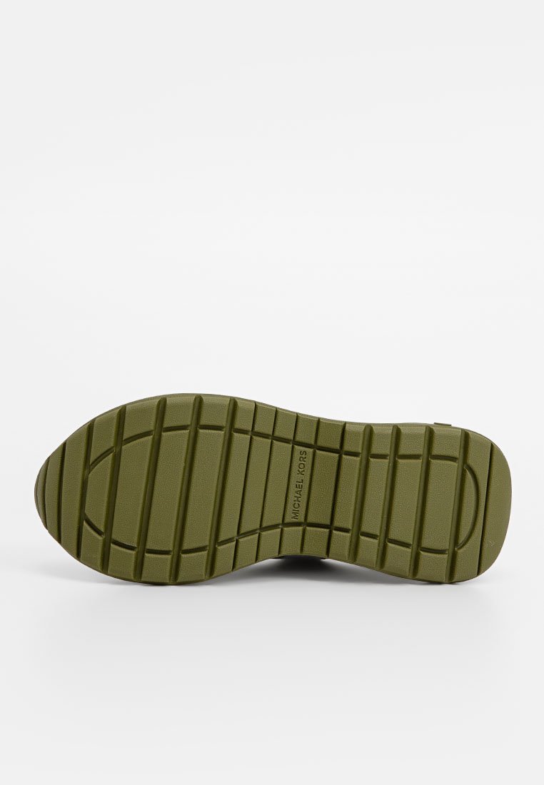 Suola in gomma verde con un motivo testurizzato per una maggiore aderenza e il marchio "MICHAEL KORS". Progettata per garantire trazione e durata.