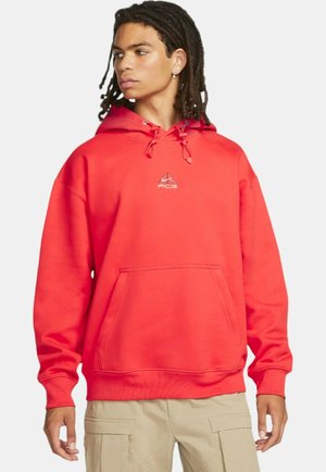 Rød fleece hoodie med en frontlomme, snor i hætten og et lille hvidt logo på brystet. Den har ribbede manchetter og kant.