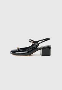 Musta patentoitu nahkainen slingback-kengä, jossa on pyöristetty kärki, nilkkaremmi ja kultainen yksityiskohta. Kengässä on loivan korko ja teksturoitu pinta.