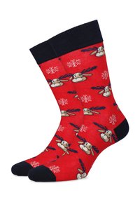 Czerwone skarpetki z granatowym ściągaczem, zdobione wzorem reniferów i płatków śniegu. Wykonane z miękkiego, elastycznego materiału dla komfortu.