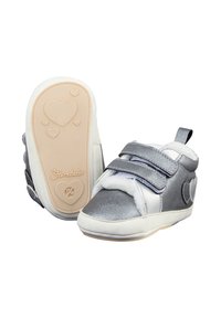 Silver and white baby shoes with heart details, two Velcro straps, plush lining, and a beige sole embossed with hearts and the brand name.